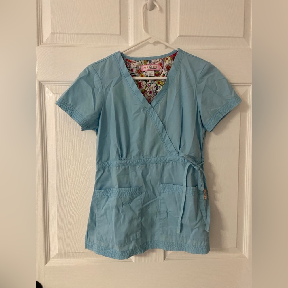 KOI by KELLY PETERSEN Blue Tropical Printed Lining Scrub Top